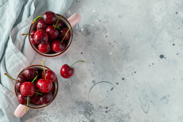 Two pink mugs with fresh ripe cherries