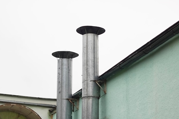 Two pipes on a green building closeup