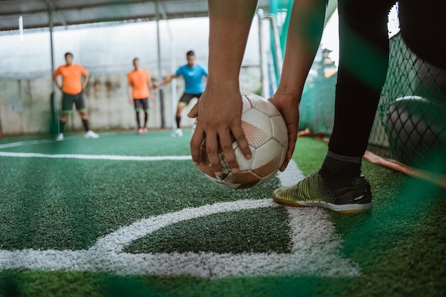 Two player hands holding the ball taking a corner kick