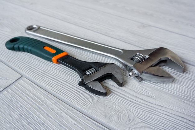 Two plumbing adjustable wrenches on the light table surface