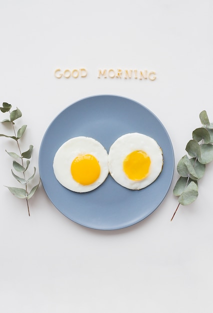 Two poached eggs on a plate with Good Morning