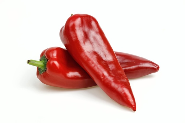 Two pointy red peppers on white background