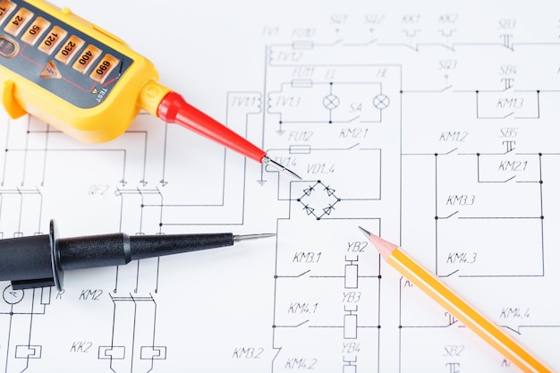 The two-pole voltage indicator lies on the electrical drawing. Testing and verification of power grids