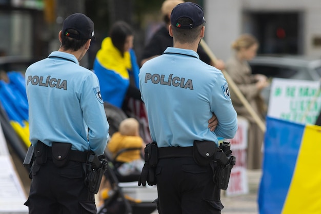 Two police officers stand at the protest of the ukrainian rally in portugal