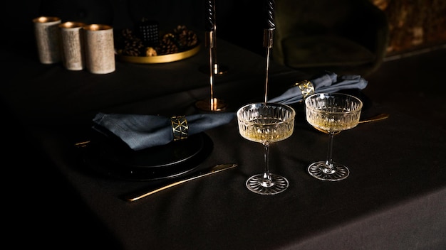 Two popular vintage champagne glasses on a dark background of the lux served table. Festive dinner or romantic date concept