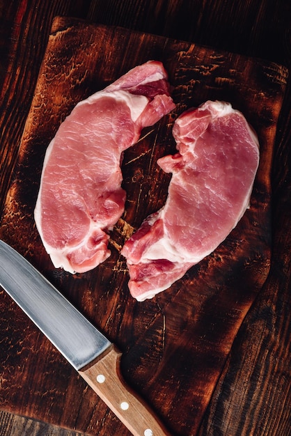 Two pork loin steaks with knife