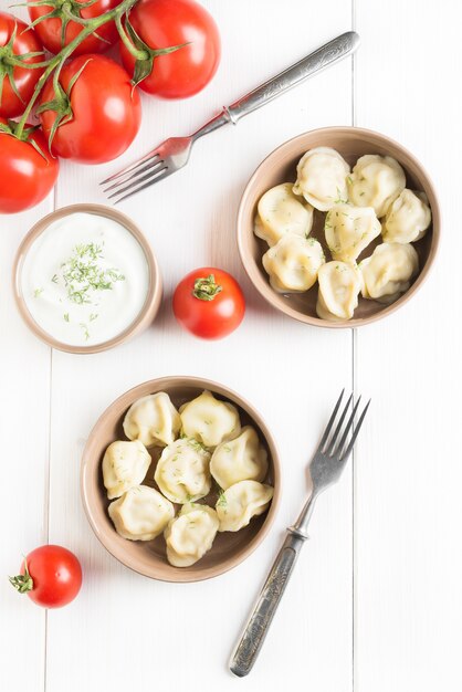 Due porzioni di gnocchi di carne sul tavolo bianco