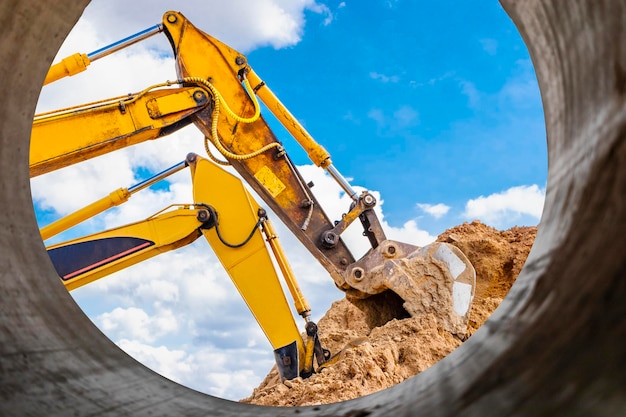 Two powerful excavators work at the same time on a construction site sunny blue sky in the background Construction equipment for earthworks