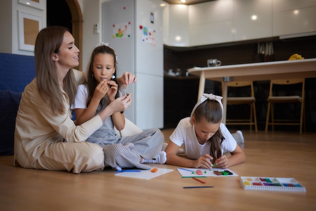 Foto due bambini in età prescolare che giocano con la plastilina colorata e si divertono si concentrano sulla ragazza a destra