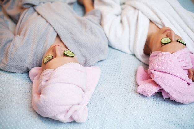 Two pretty girls doing facial spa treatments.