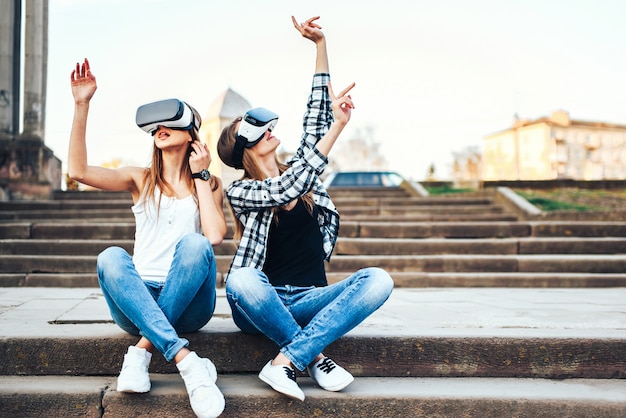 Foto due belle ragazze godono di occhiali per realtà virtuale all'aperto