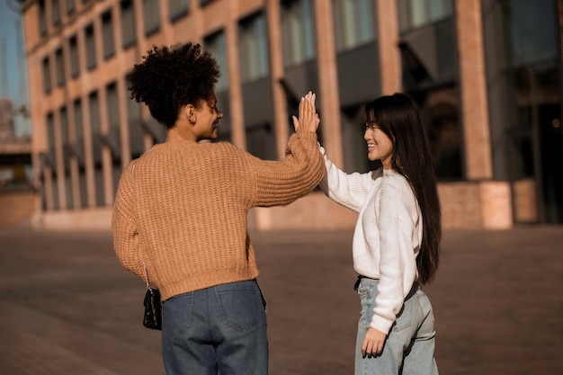 Foto due belle ragazze che camminano e parlano, sentendosi gioiose