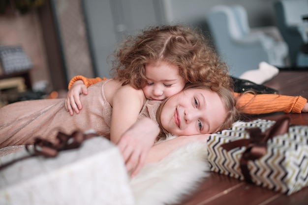 Two pretty sisters are having fun in a cozy living room