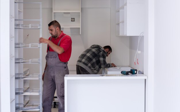 Photo two professional workers installing a new stylish modern kitchen furniture