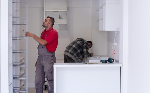 two professional workers installing a new stylish modern kitchen furniture