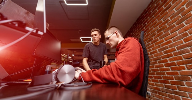 two programmers working on new project while sitting at the table and feeling concentrated. developing programming and coding technologies concept