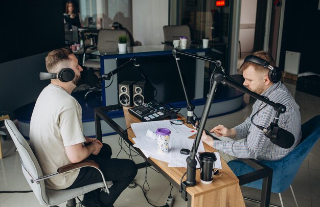 Two radio hosts moderating a live show for radio