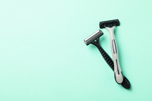 Two razors on mint background, space for text