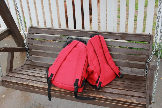 Фото Два красных ребенка с рюкзаками лежат на деревянном
