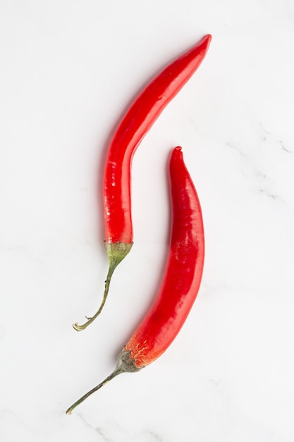 Two red chili peppers isolated on a white background. Top view, flat lay. Cooking, spices and kitchen concept. Mexican, thai kitchen