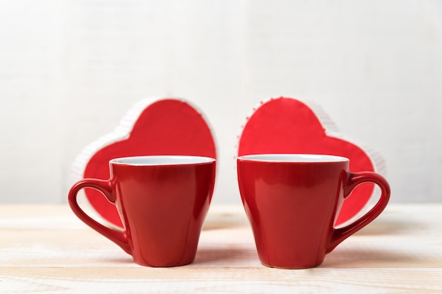 Two red cups and heart shaped boxes. Date, Valentine's Day.