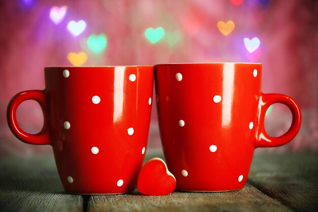 Two red cups on table on lights background