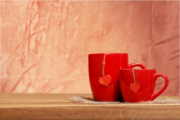 Two red cups on wooden table