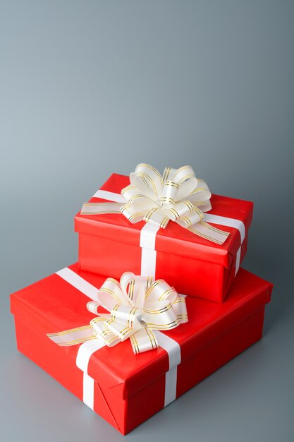 Two red gift box with a white ribbon and a bow