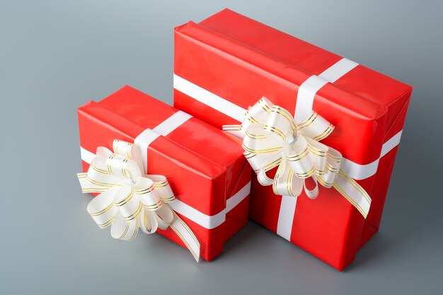 Two red gift box with a white ribbon and a bow