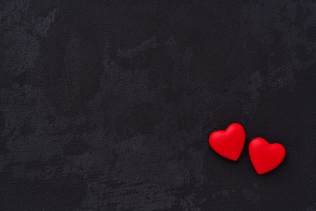 Premium Photo | Two red heart on black background. top view