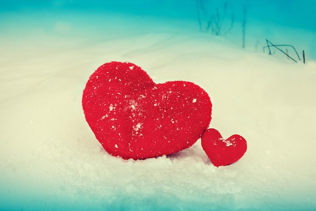 Two red hearts big and small in the snow