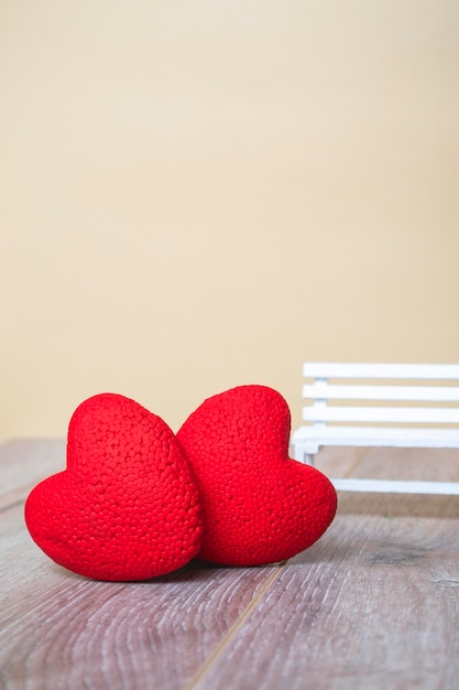 Two red hearts close up on a wooden background. With place for text. Vertical format