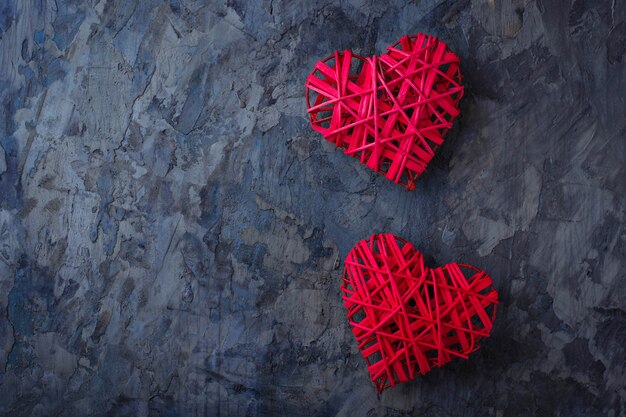 Two red hearts on concrete background, top view