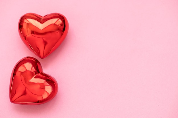 Two red hearts on a pink background