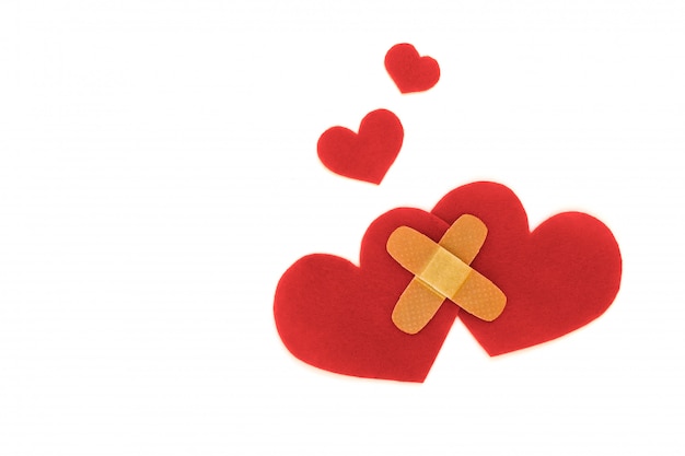 Two red hearts symbol with medical patch on white background