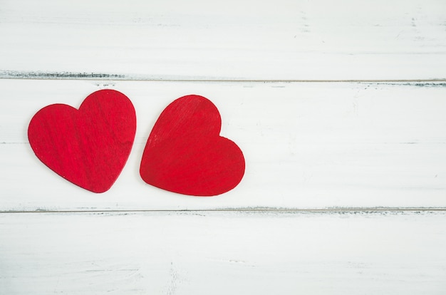 Two red hearts on white wooden background, Love concept.