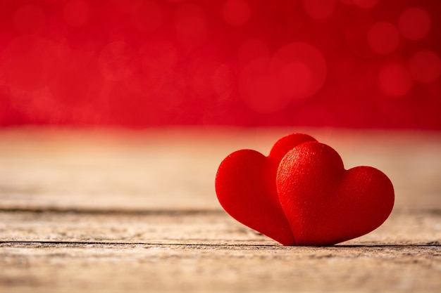 Two red hearts on wooden table