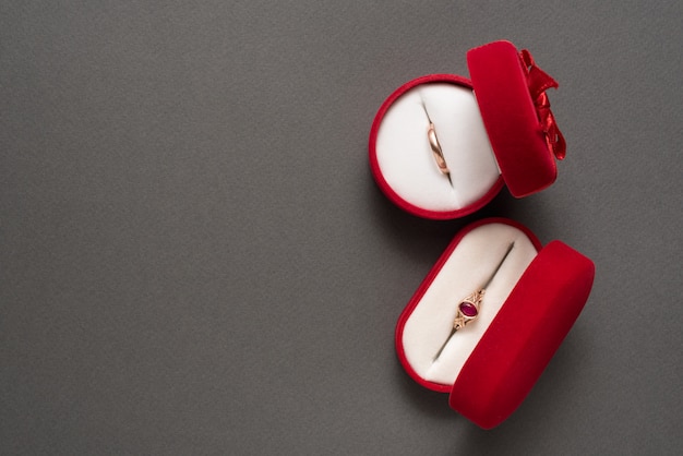 Two red jewelry boxes with jewelry on a black background. Top view. Copy space