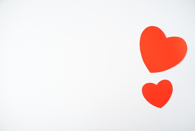 Two red paper hearts on the light (white) background. Valentine's day concept. Flat lay, top view, space for text.