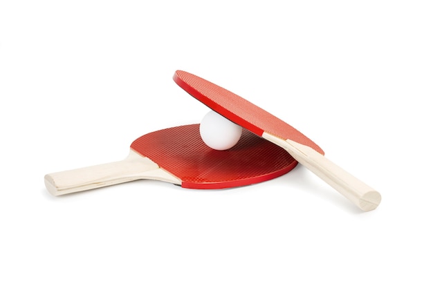 Two red ping pong paddles and a white ball on white