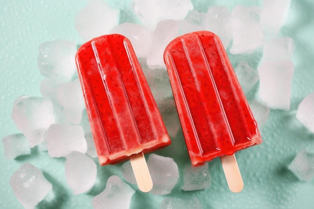 Two red popsicles with the word ice on them