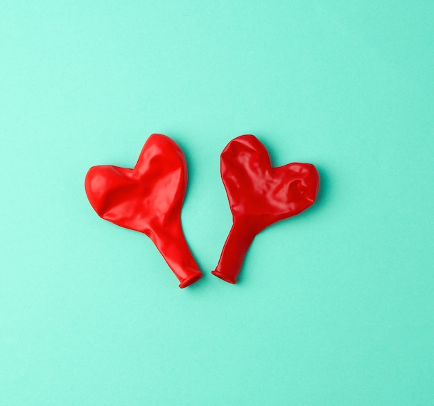 Два красных резиновых шарика сдуваются в форме сердца