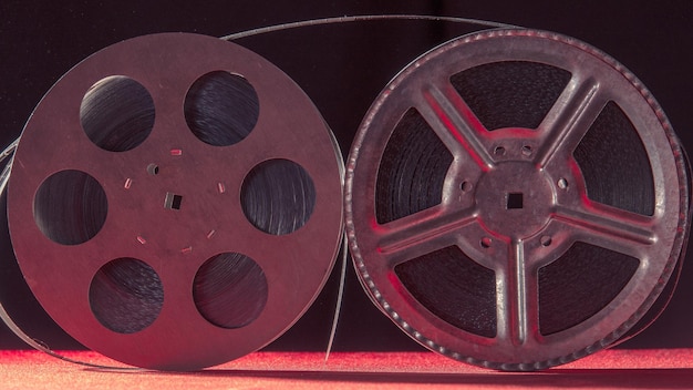 Two reel of film standing on a red table