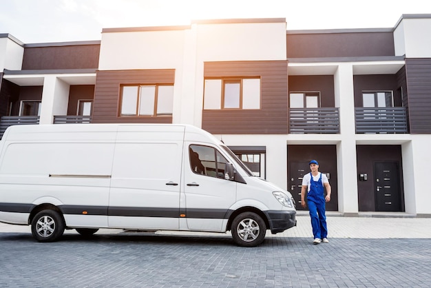 Two removal company workers unloading boxes from minibus into new home