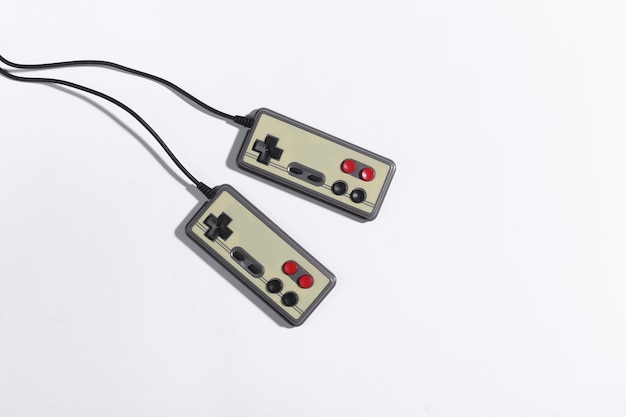 Photo two retro gamepads on white background with shadow. retro gaming. top view