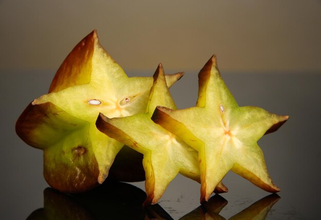 Photo two ripe carambolas on yellow background