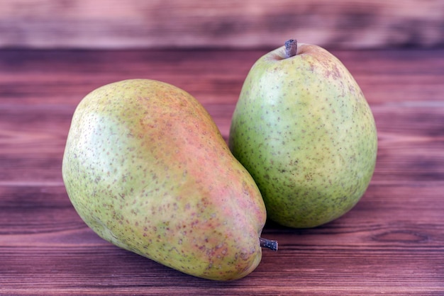 Two ripe pears on an old wooden table.