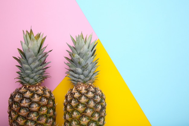 Two ripe pineapples on a colorful background