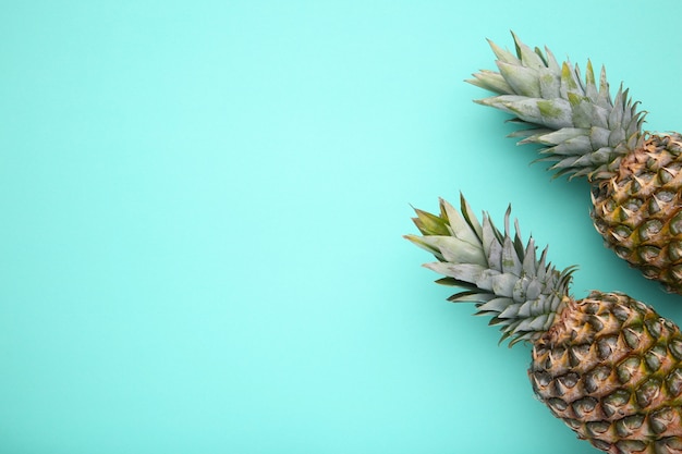 Two ripe pineapples on a mint background