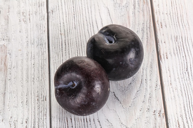 Photo two ripe sweet black plums isolated